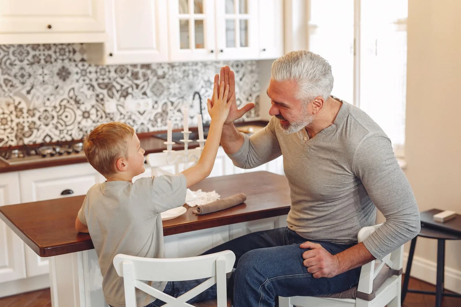 Vater und Sohn geben sich in der Küche ein High five